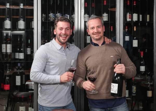 Deux personnes devant une cave à vin