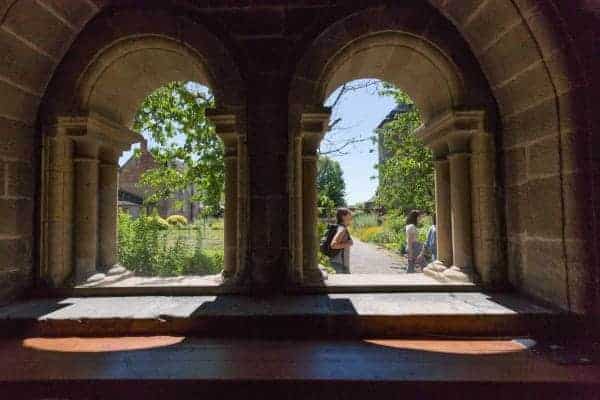 vue sur le jardin du cloître de l'abbaye d'Aubazine à travers des arcades en pierres