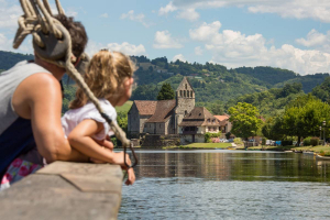 Vue sur l'abbatiale Saint-Pierre de Beaulieu depuis une gabare sur la Dordogne