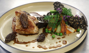 Assiette de veau de lait à la planche servi avec de la purée de carottes, morilles et sauce balsamique.