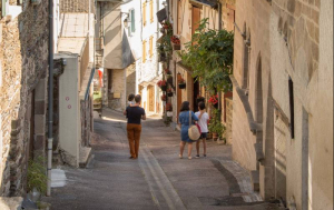 Famille de dos entrain de descendre une ruelle ensoleillée de Donzenac.