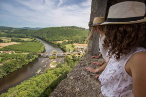 Une famille regarde le paysage du haut du château de Castelnaud en Dordogne