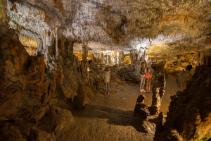 Une famille visite une salle souterraine du gouffre de la Fage