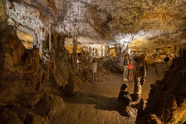 Une famille visite une salle souterraine du gouffre de la Fage
