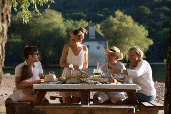 A family eating on a picnic table at Lac du Causse