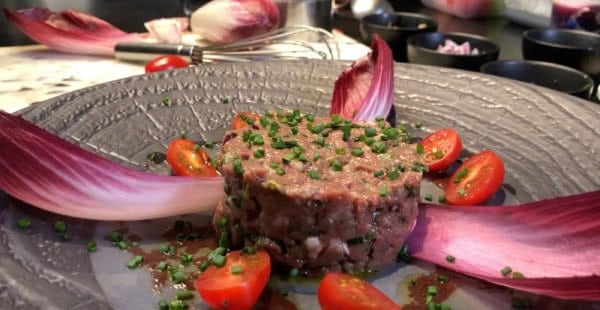 Presentation plate of duck tartare with violet mustard