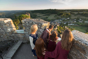 Une famille en costumes médiévaux, observe le panorama depuis la tour du château de Turenne