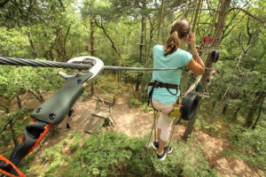 Une jeune fille réalise un parcours d'accrobranche