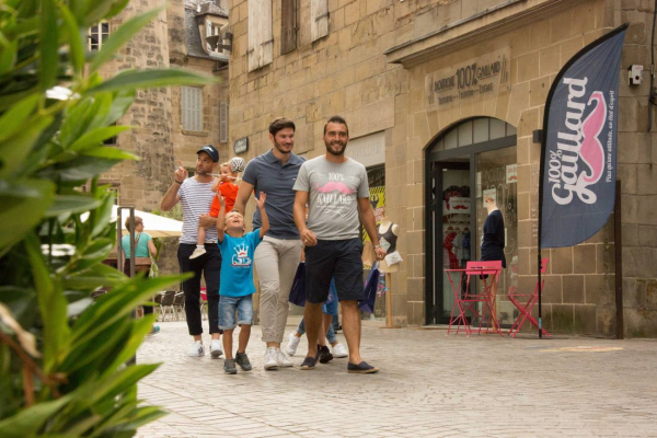 Groupe de personnes devant la Boutique 100% Gaillard, se promenant.