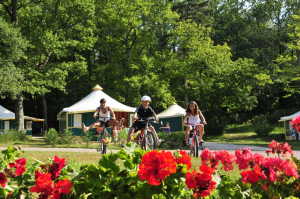 Trois personnes font du vélo dans le camping du Coiroux
