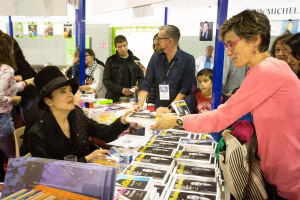 L'écrivaine Amélie Nothomb remet un livre dédicacé à une de ses lectrices