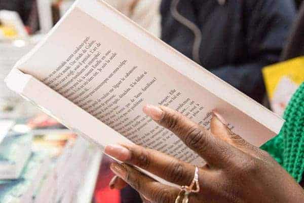 Vista de la mano de una dama hojeando un libro