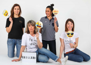 Quatre gaillardes tiennent des pancartes avec différents émojis