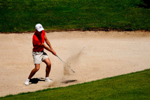 Un golfeur est en train de taper dans une balle avec son club
