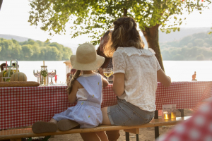 Jeune femme et petite fille attablées au bord du Lac du Causse