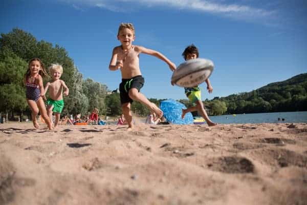 groups of children playing rugby on the beach at Lac du Causse