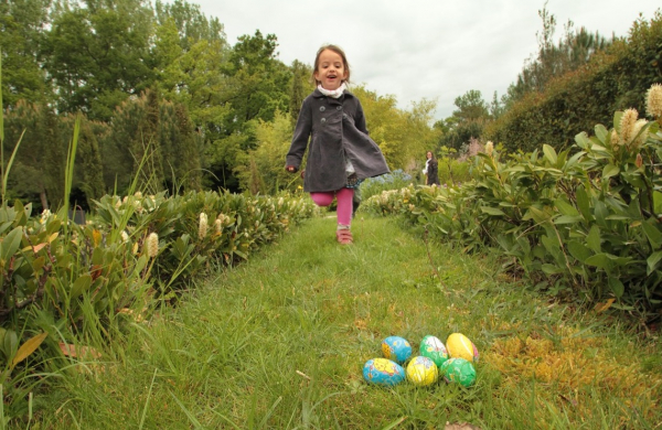 Klein meisje dat deelneemt aan een eierenjacht in de Jardins de Colette