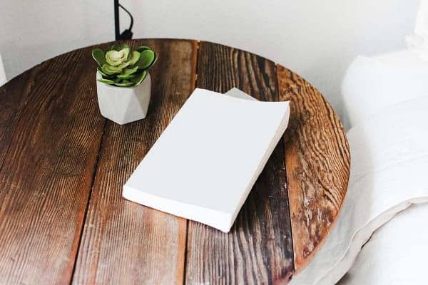 Un livre est posé sur une table de chevet dans une chambre