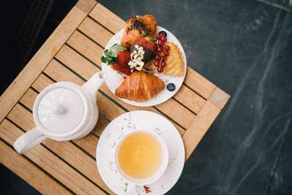 Tasse de thé avec théière et petites douceurs