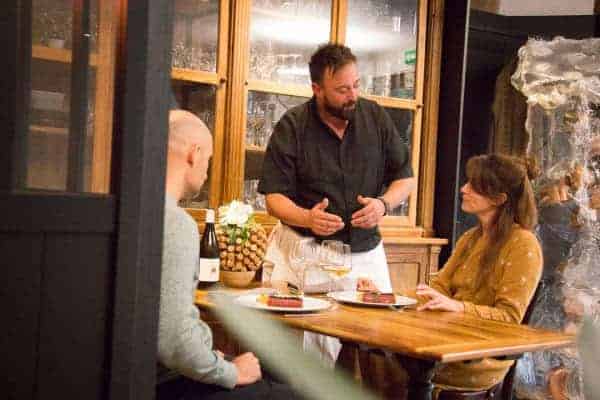 Le Chef du restaurant En Cuisine échange avec ses clients