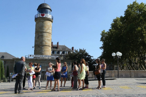 Un groupe accompagné d'un guide lors d'une visite guidée devant le phare à Brive