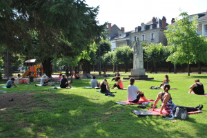 Groupe de personnes faisant du yoga dans le parc derrière la Halle Gaillarde