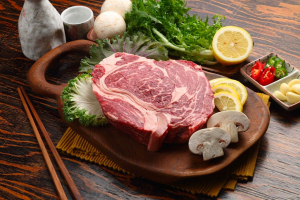 cote de boeuf crue sur planche avec condiments