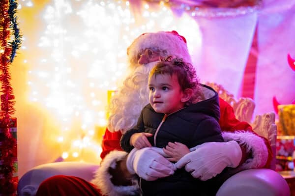 Père-Noël de Brive avec enfant dans son chalet