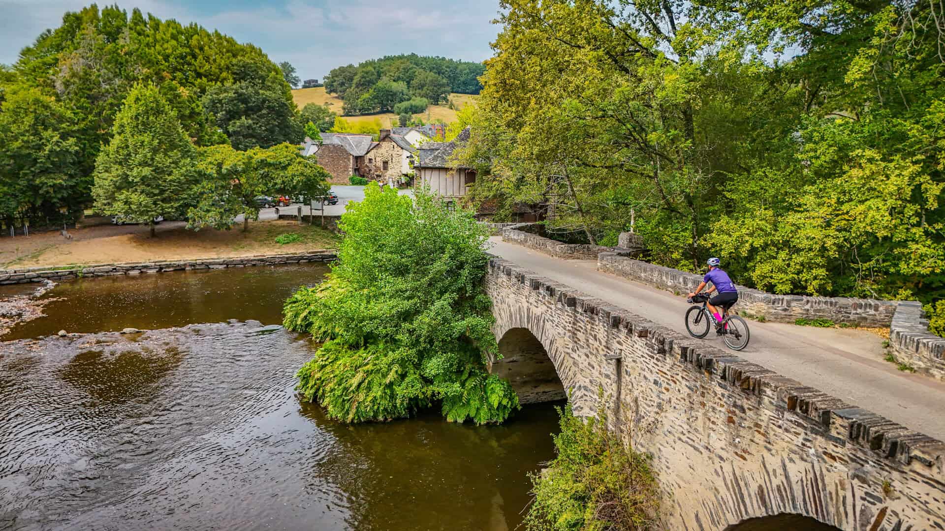 Un cycliste sur un pont , une Idée de séjour écoresponsable pour visiter Brive sans voiture en Corrèze