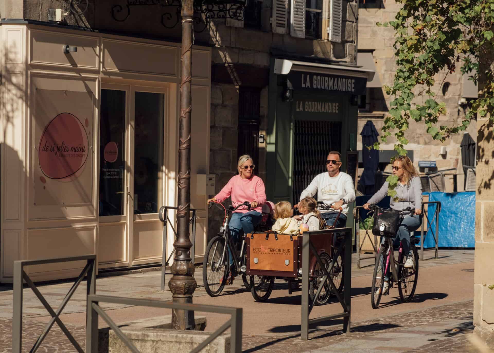 Groupe d'adultes et enfant faisant du vélo en centre ville de Brive un jour d'automne.