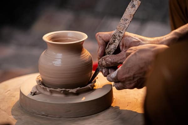 main realisant une poterie en forme de vase